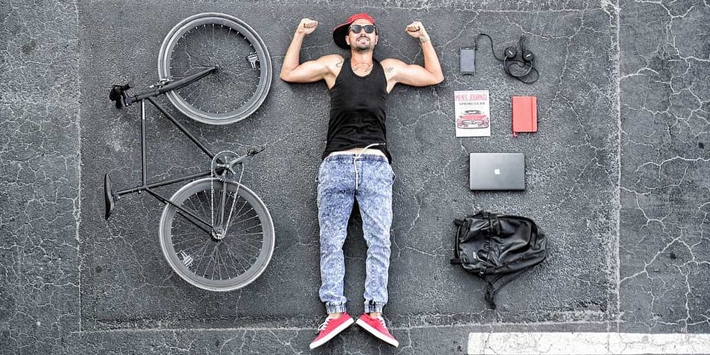 Man in Black Tank Top Laying on Gray Concrete Surface